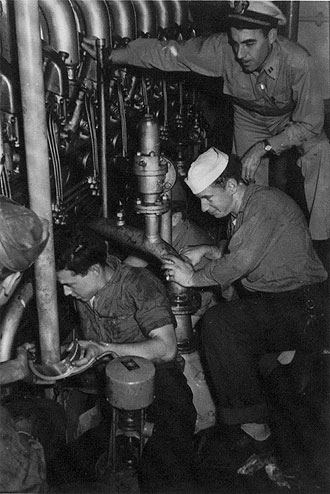 file:/activities/oralhistory/cappics/slater1942_1945_engine, alt: Paul Slater and others working in the engine room of the USS Walter S. Brown